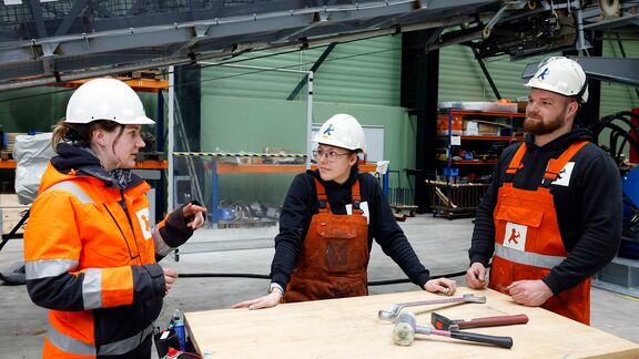 Werknemers van Ampelmann tijdens een debriefing in de werkruimte