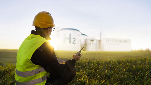 Man kijkt naar waterstofterminal met portofoon in de hand