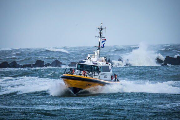 Snelvarende tender in stormachtig weer nabij de blokkendam