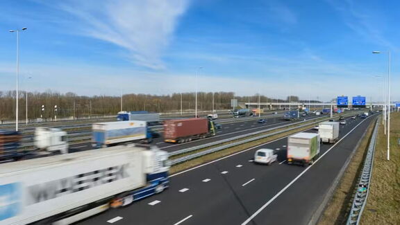 Snelweg tussen Maasvlakte en Vaanplein met rijdend vrachtverkeer onder een blauwe lucht.