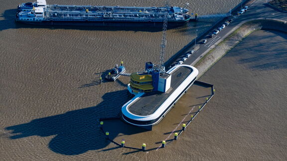 „Luftaufnahme eines Frachtschiffs neben einer industriellen Plattform im Hafen.“
