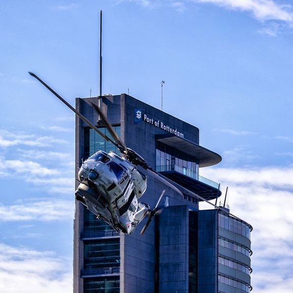 Helikopter met World Port Center op de achtergrond