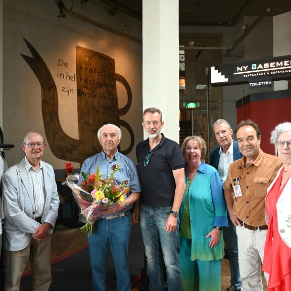Bram Oosterwijk (met bloemen) ontvangt van Boudewijn Siemons (rechts van hem) het Sleepanker van de haven Rotterdam onder toeziend oog van havenvrienden (foto Ries van Wendel de Joode)
