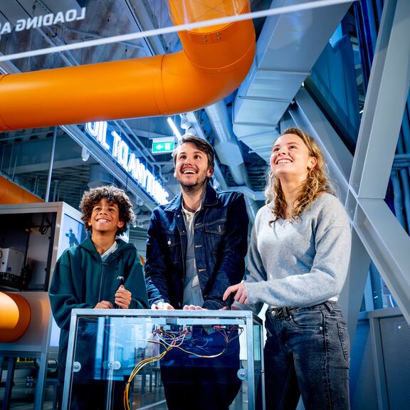  Een gezin staat bij een  interactieve game  in Portlantis