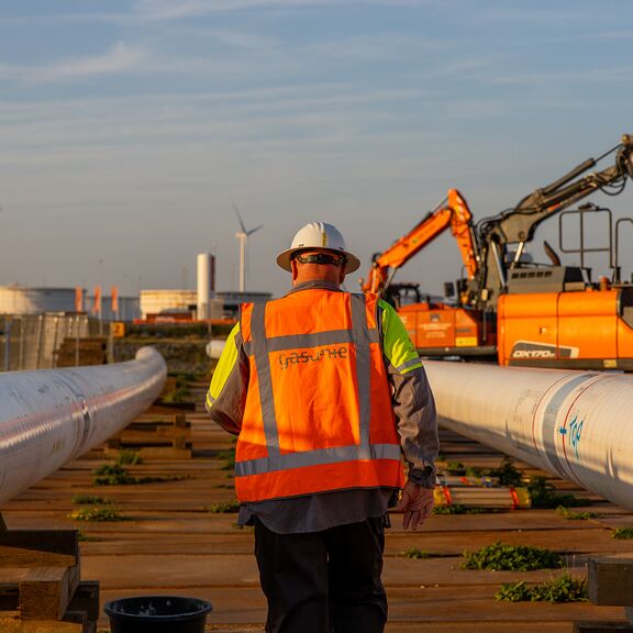 Medewerker gasunie loopt bij nieuwe waterstofleiding in de Rotterdamse haven