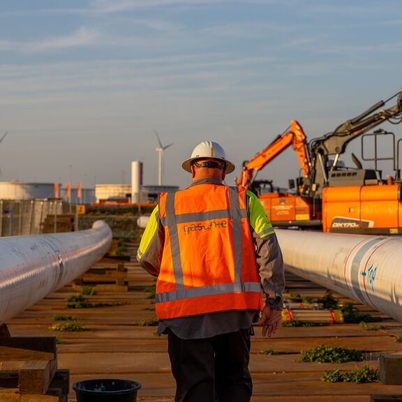 Medewerker loopt tussen de waterstofbuizen