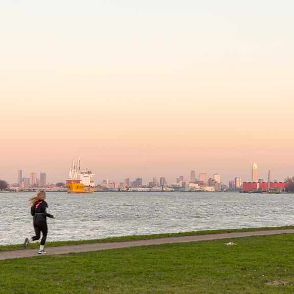 Vrouw loopt hard langs de Nieuwe Maas ter hoogte van Pernis