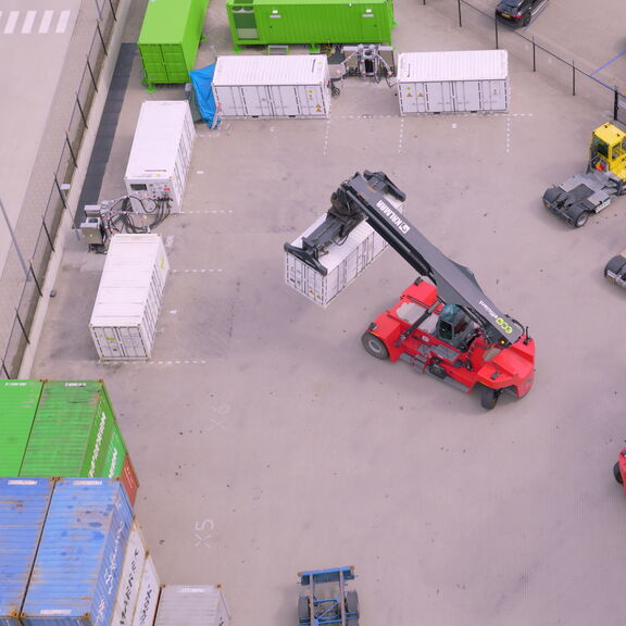 <meta charset="utf-8">Een reachstacker wisselt een lege voor een volle ZES-pack bij het laadstation in Alblasserdam